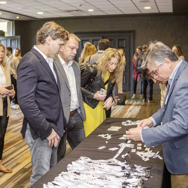 Asistentes retirando sus credenciales en la mesa de acreditación del Premio Lealtad