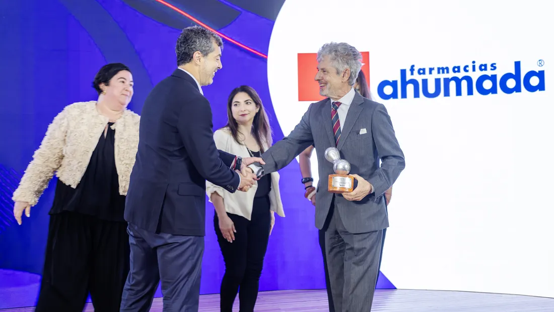 Entrega del galvano del Premio Lealtad a Farmacias Ahumada, con un apretón de manos sobre el escenario
